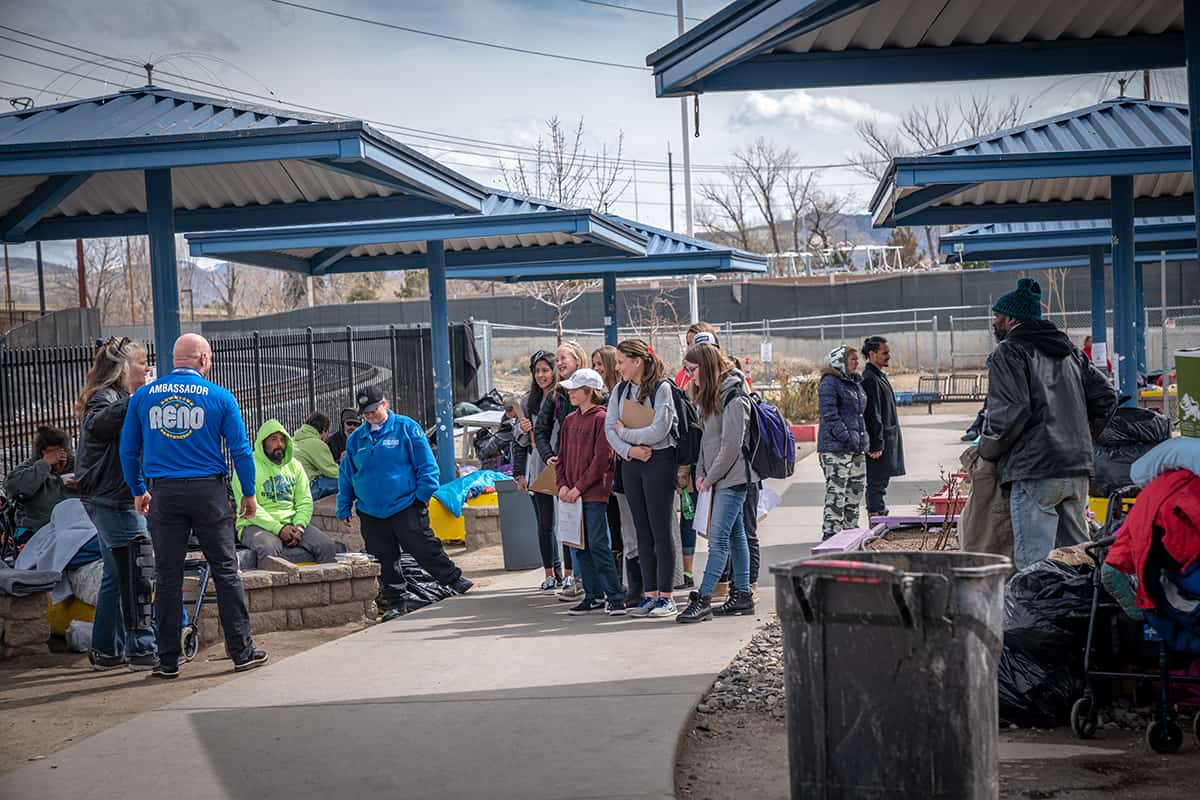 a man talking to students gathered around him