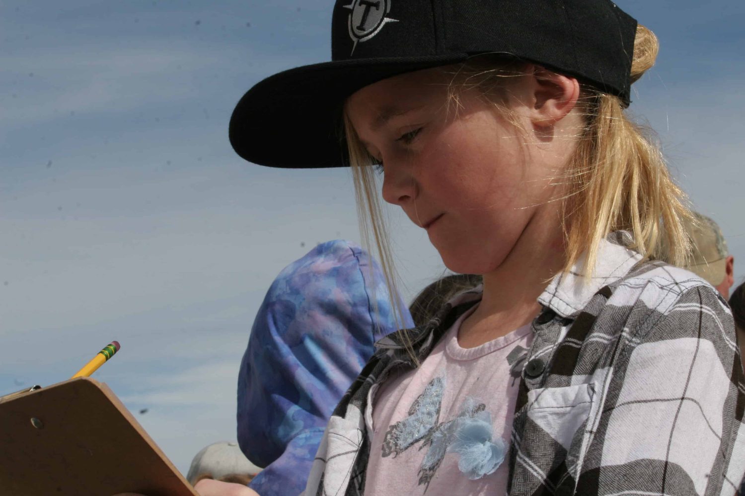a girl with a hat taking notes