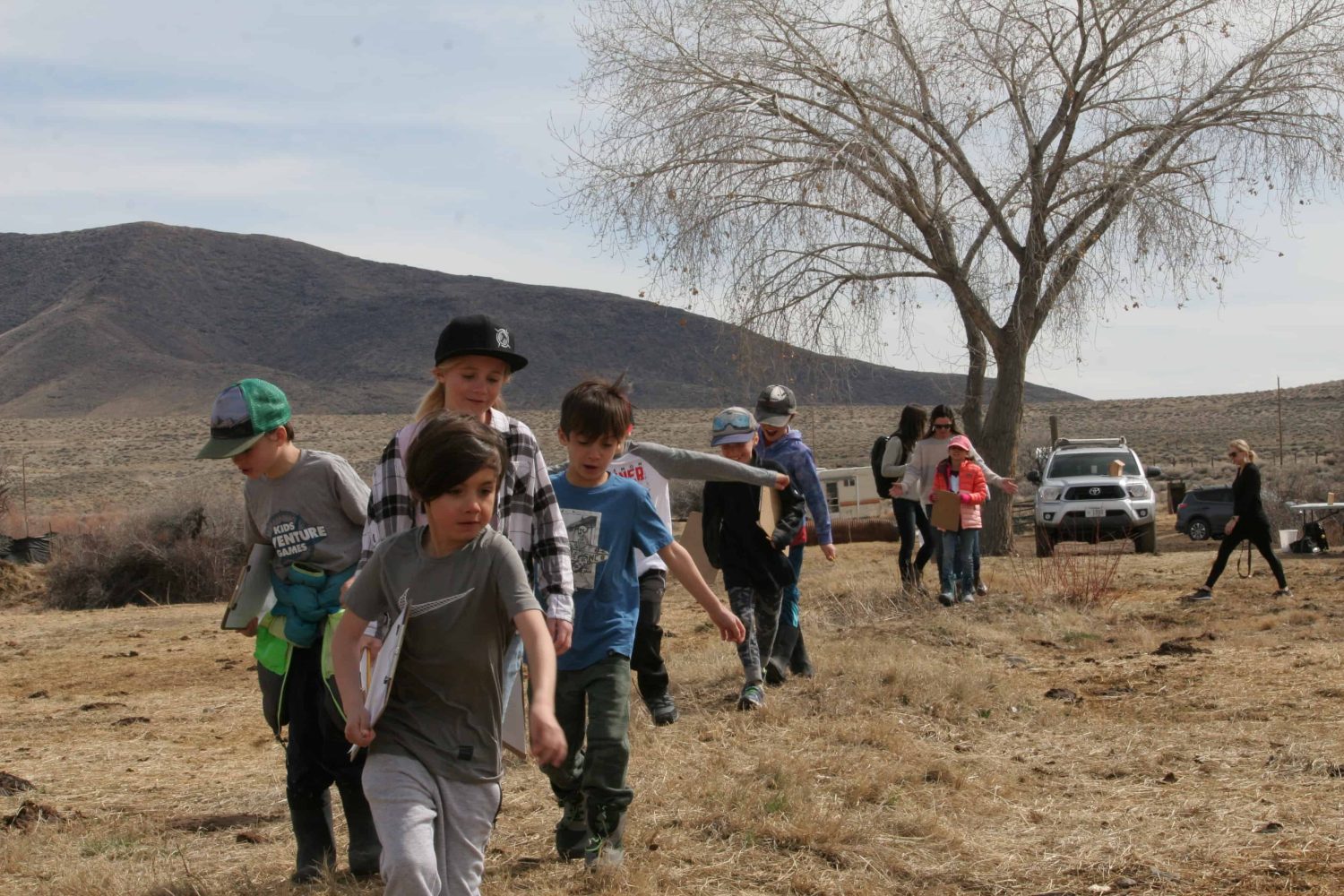 kids with their clipboards walking through a field