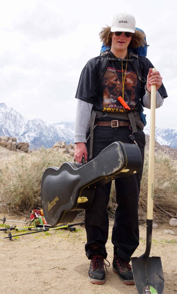 a student holding his guitar