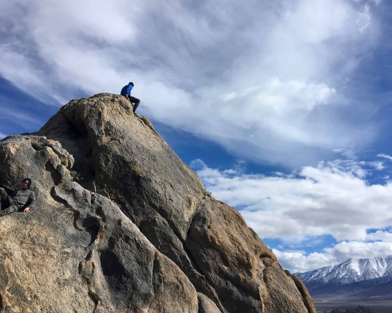 a student sits atop a hill