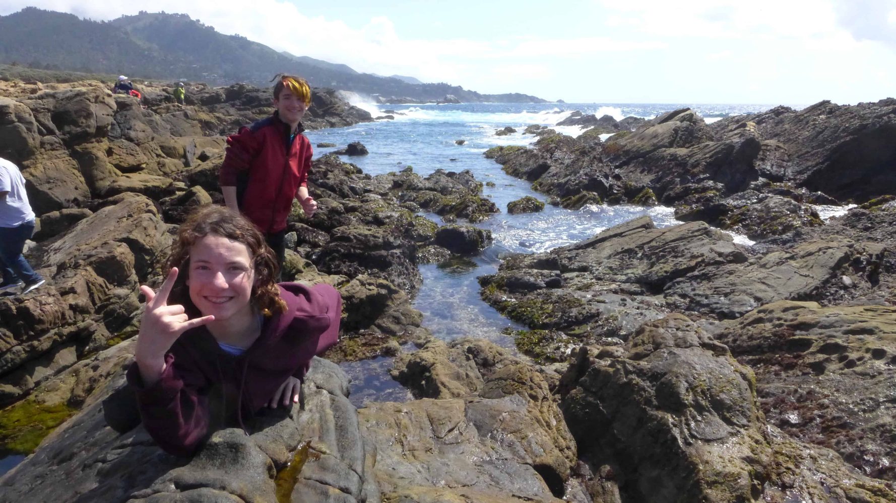 students standing on a shoreside cliff