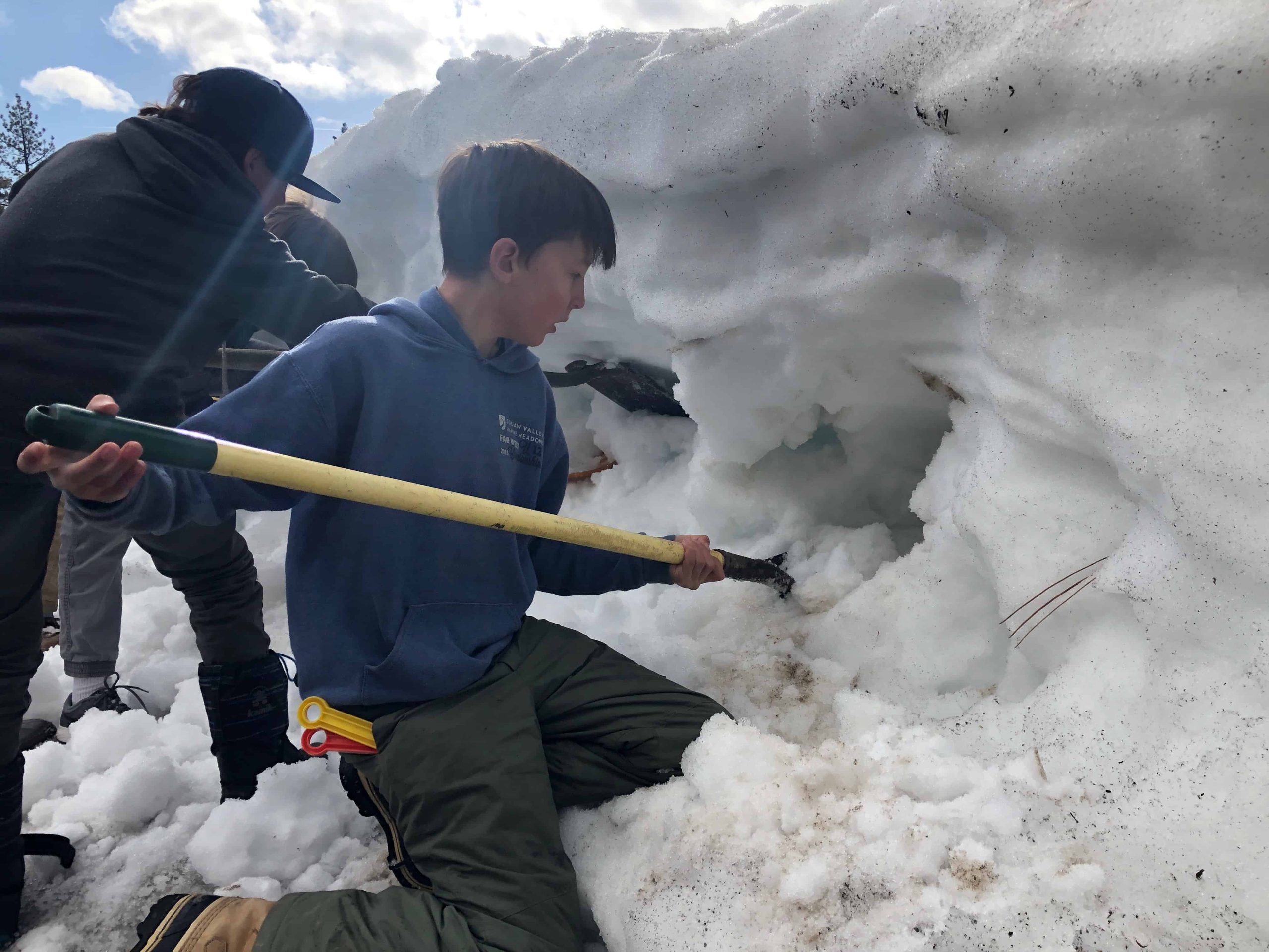 5th grader with a shovel digging through snow
