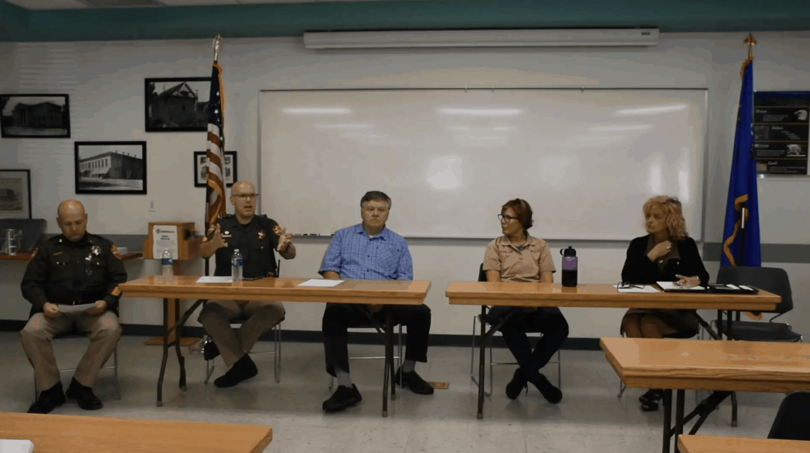 officers sitting at desks speaking to a class