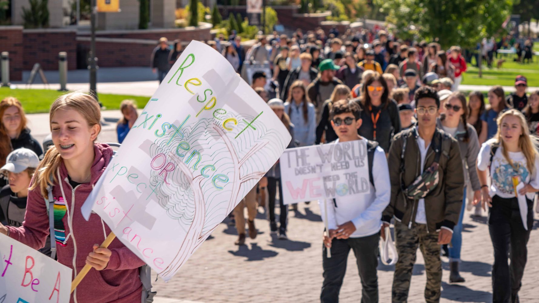 a group of student protestors wave their signs