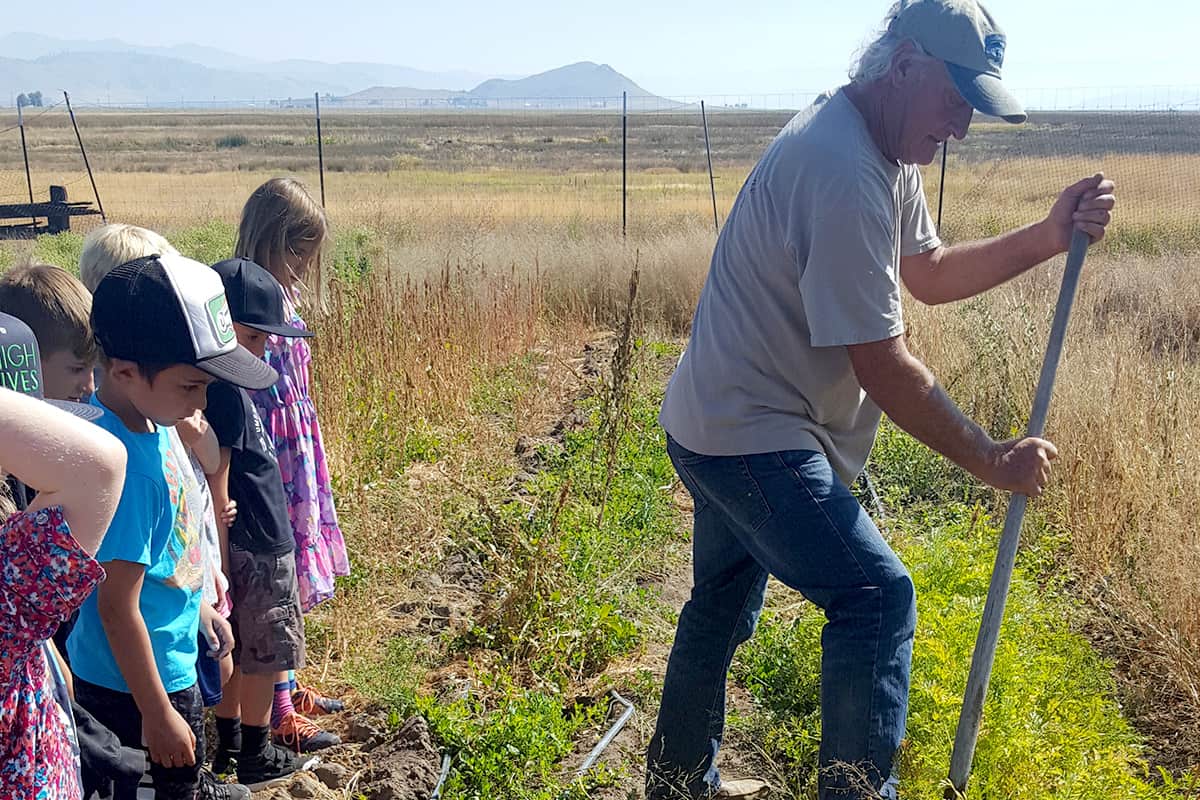 students watching a farmer work
