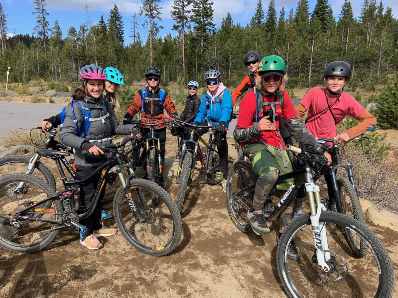 students posing with their bikes beside a trail