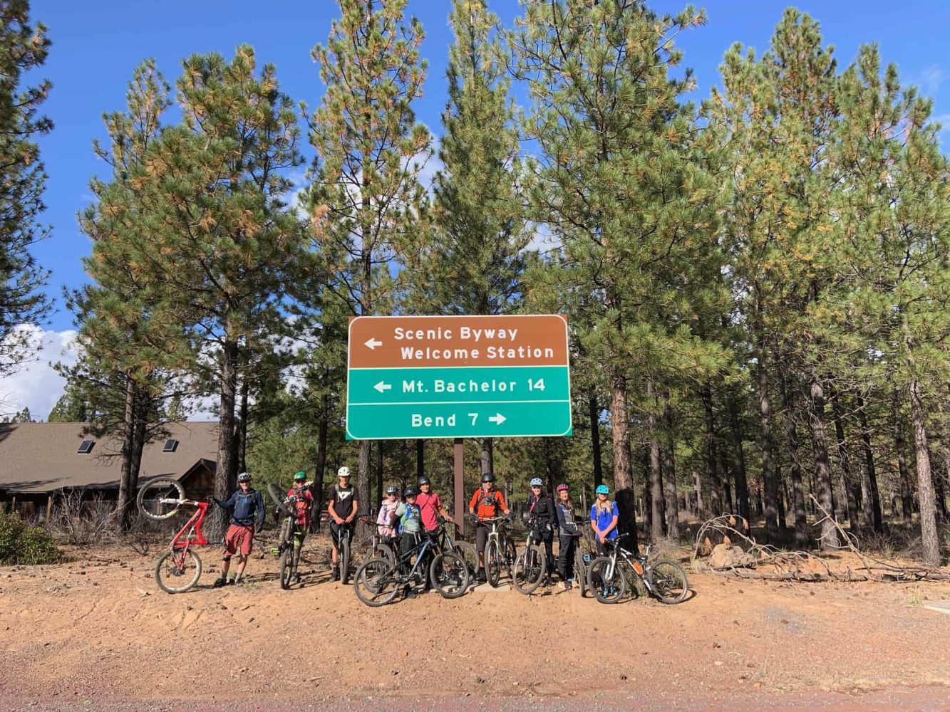 kids on their bikes in front of a roadway sign