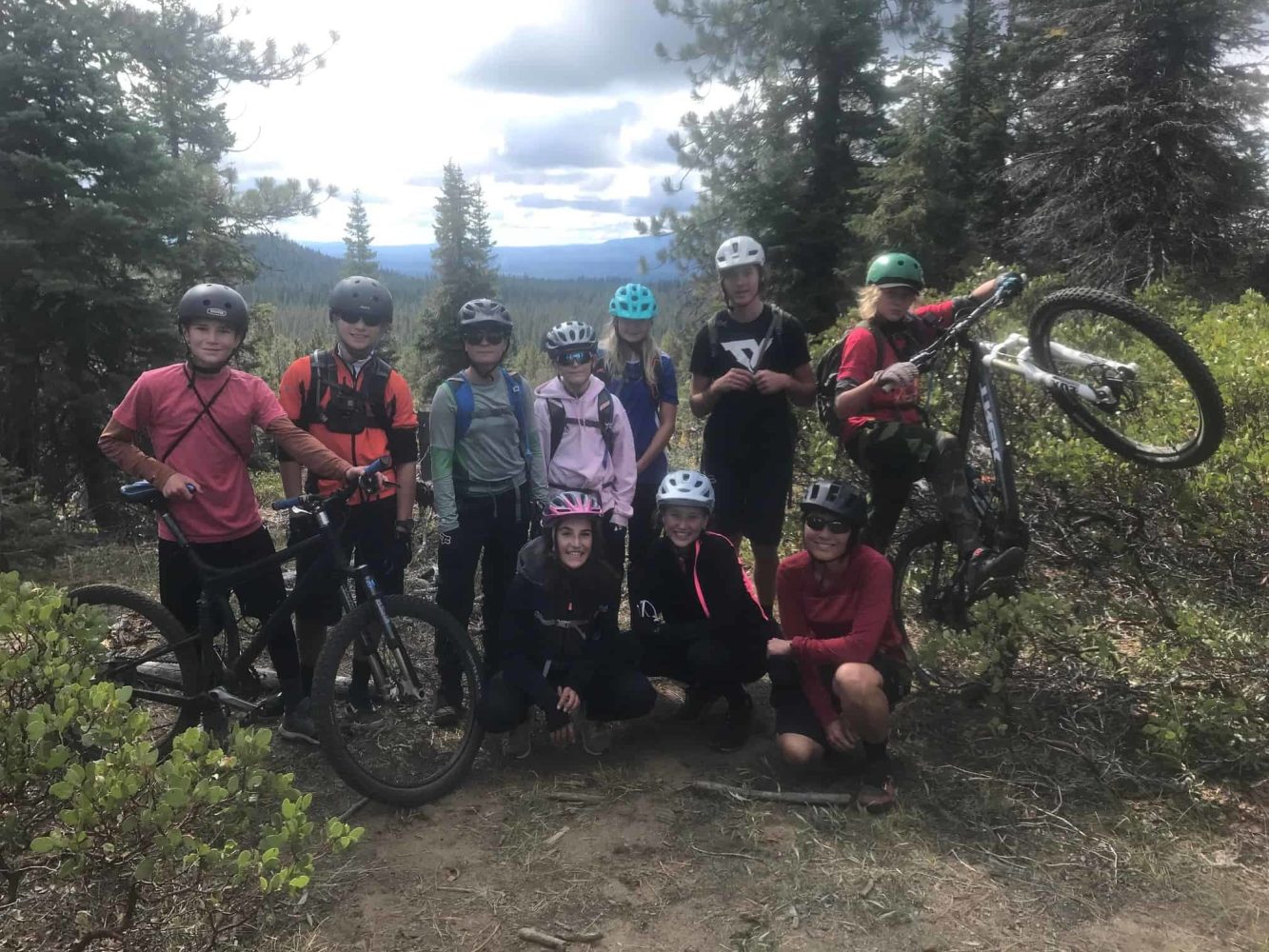 students posing with their bikes beside a trail