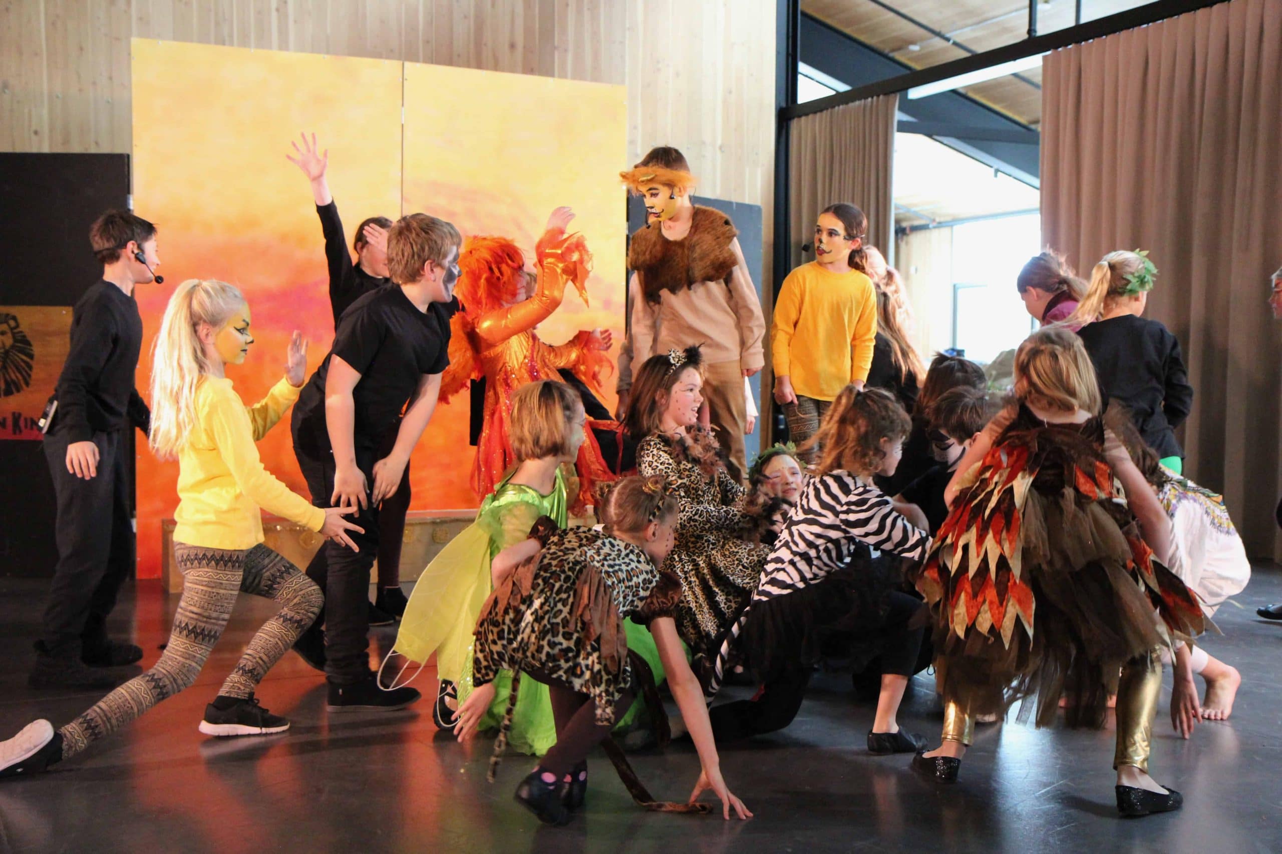 the drama club onstage in their lion king costumes