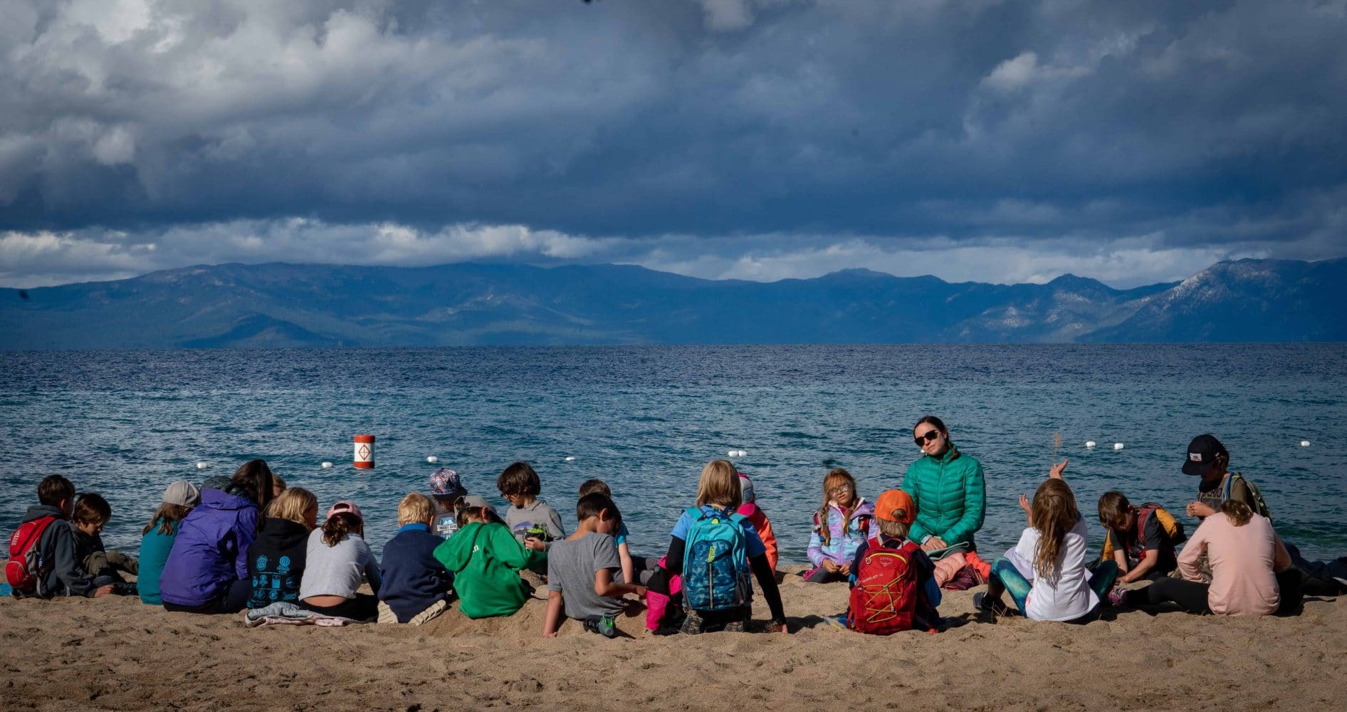 kids sitting in front of lake tahoe