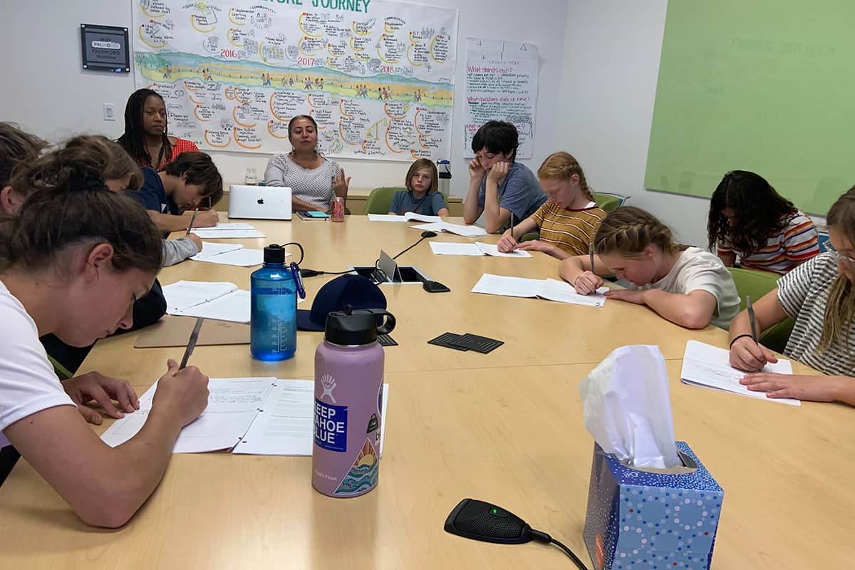 students sitting at a long desk taking notes