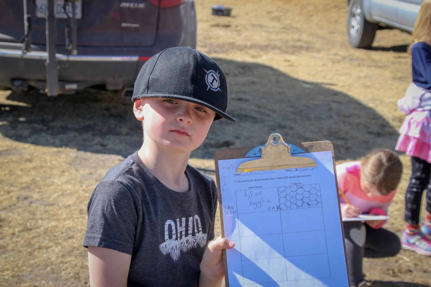 2nd grader holding up a clipboard