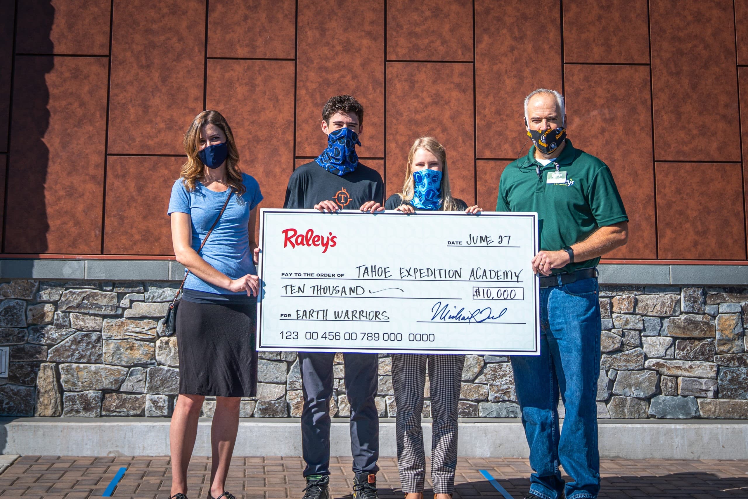 The president and vice president of the Eco Club, along with Raley's administration, holding the grant check