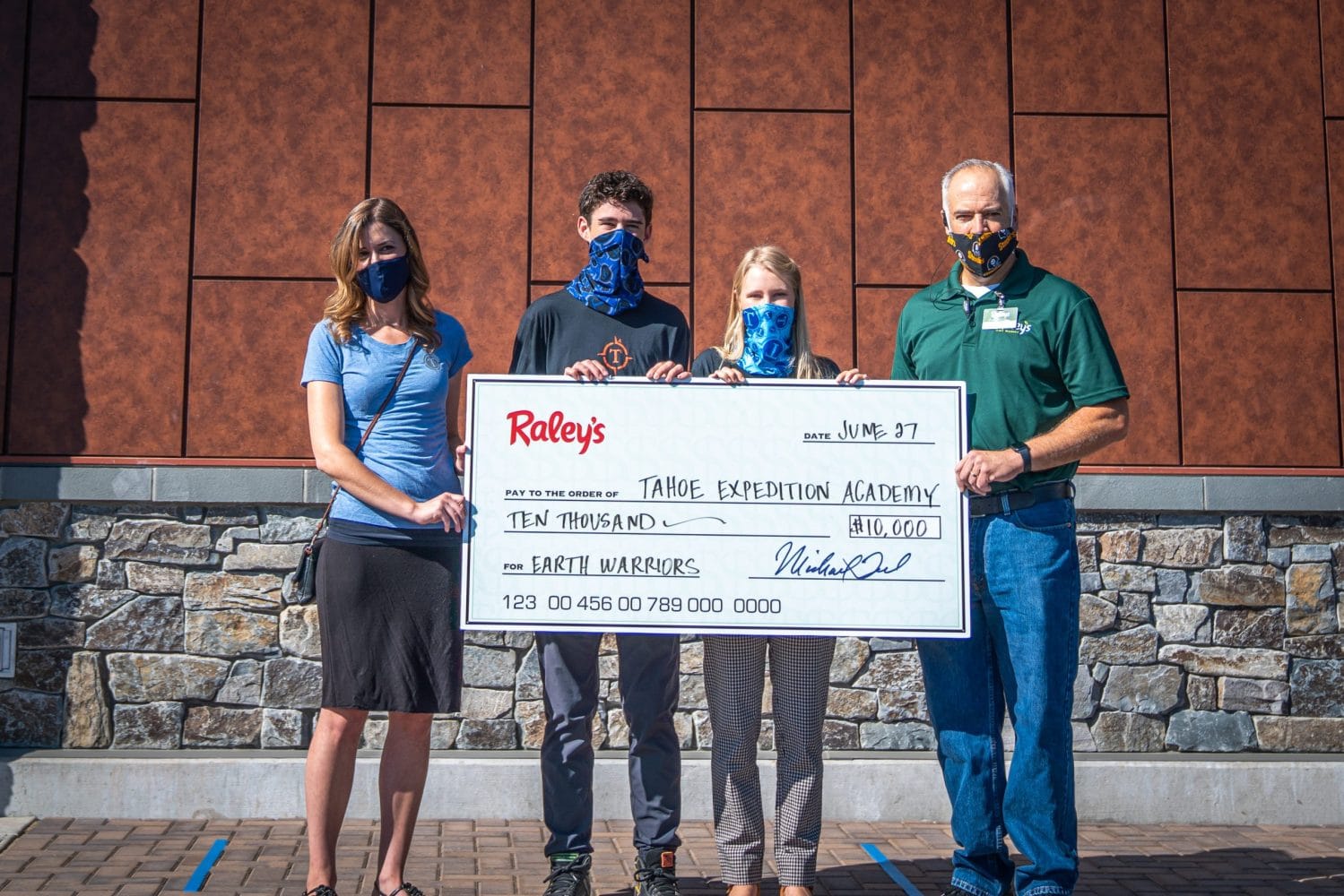 The president and vice president of the Eco Club, along with Raley's administration, holding the grant check