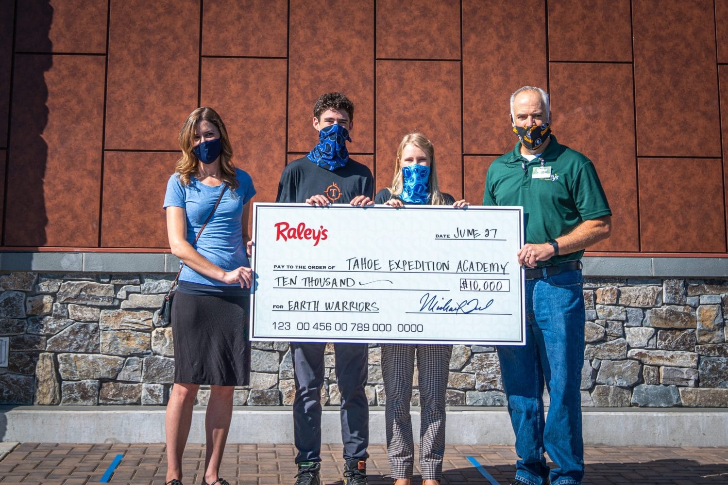 The president and vice president of the Eco Club, along with Raley's administration, holding the grant check