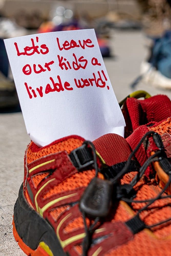 A shoe with a note that reads: Lets leave our kids a livable world!