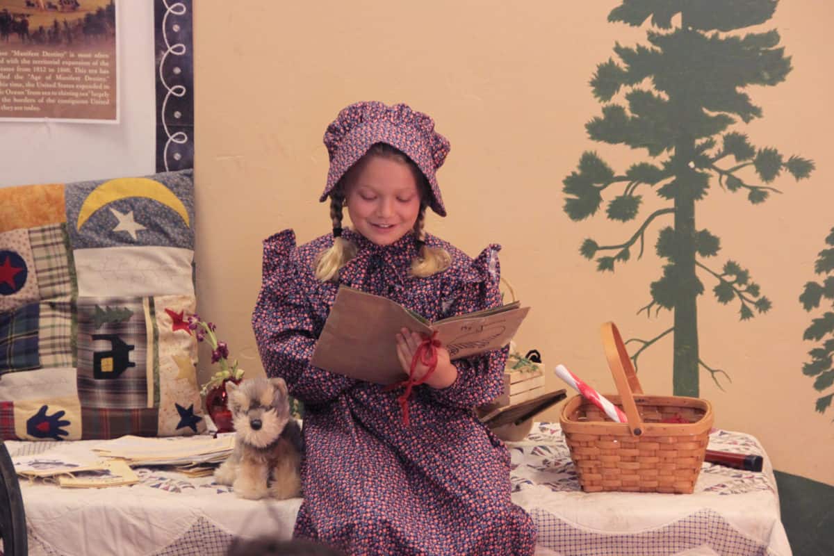 estudiante más joven con atuendo amish leyendo de un libro